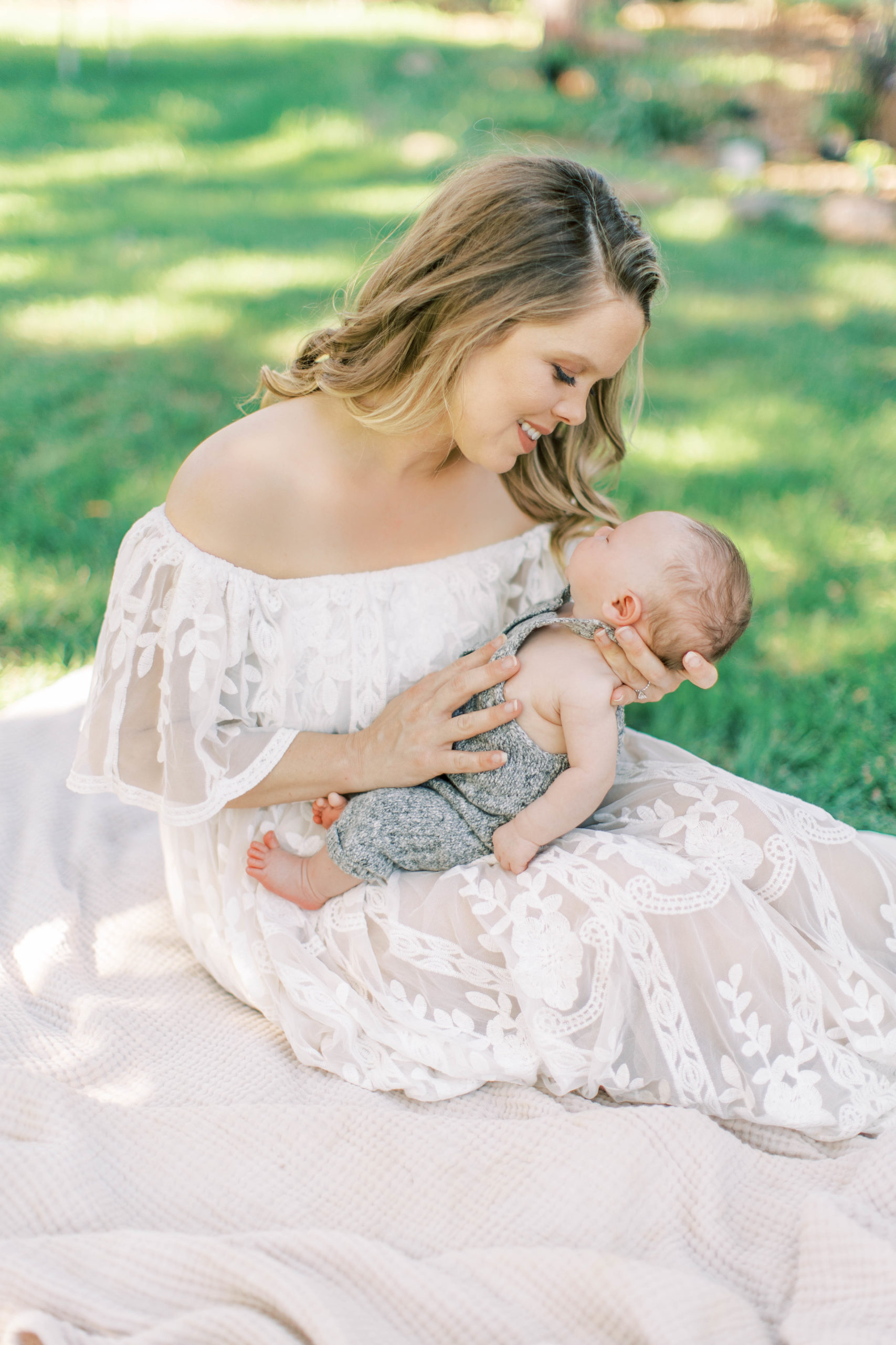Outdoor newborn session mom holding baby smiling